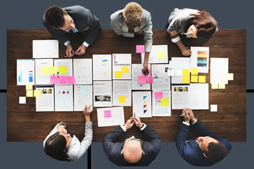 men and woman at table with many documents Digital Document Solutions, RI, MA, Kyocera, Canon, Xerox document management